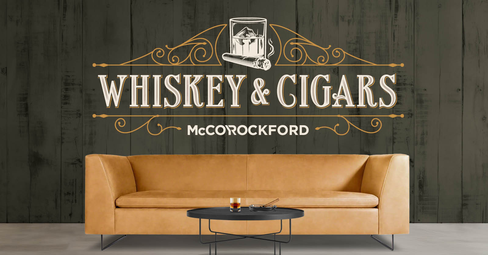 Tan leather sofa against green wall with Whiskey & Cigars logos